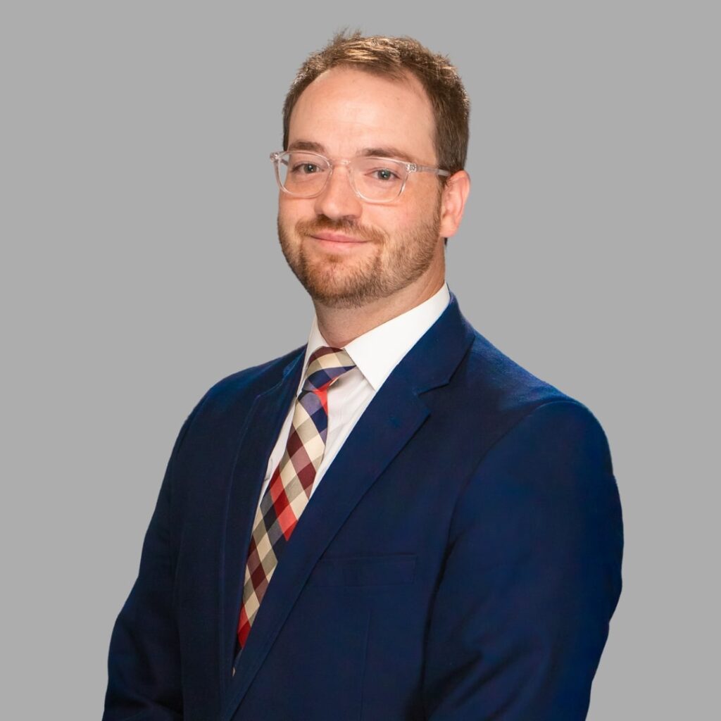 A headshot of a man in a suit
